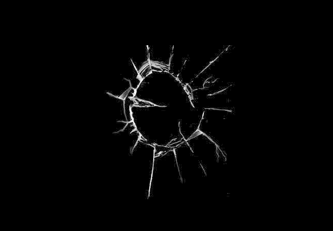 A white, circular crack appears in the center of the image, like shattered glass.