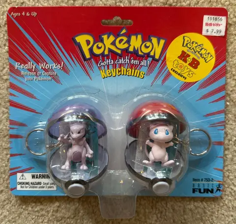 a package containing mew and mewtwo keychains. it features a blue burst design on a red background