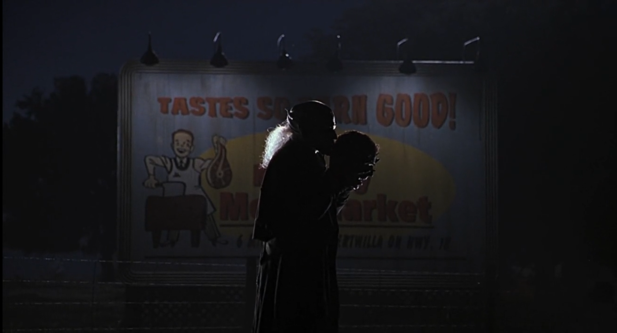 the creeper kissing a severed head cast in shadow