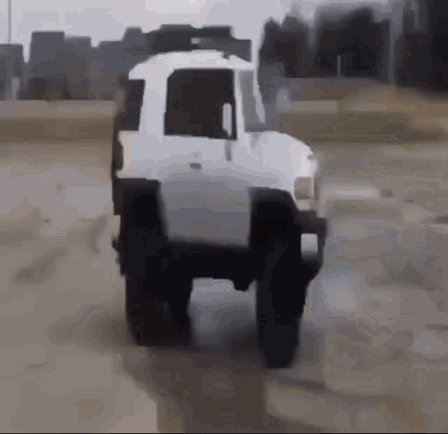 A GIF OF A SQUASHED CAR DRIVING IN CIRCLES.