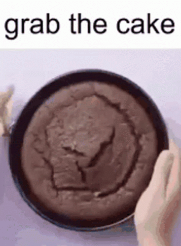 A GIF OF SOMEONE GRABBING DIRECTLY INTO THE CENTER OF A CHOCOLATE CAKE CAPTIONED 'GRAB THE CAKE'.