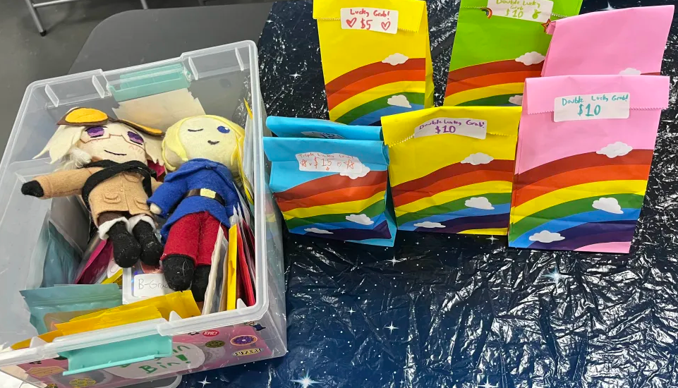 A collection of lucky grab bags, next to a bargain bin with handmade Hetalia plushies
