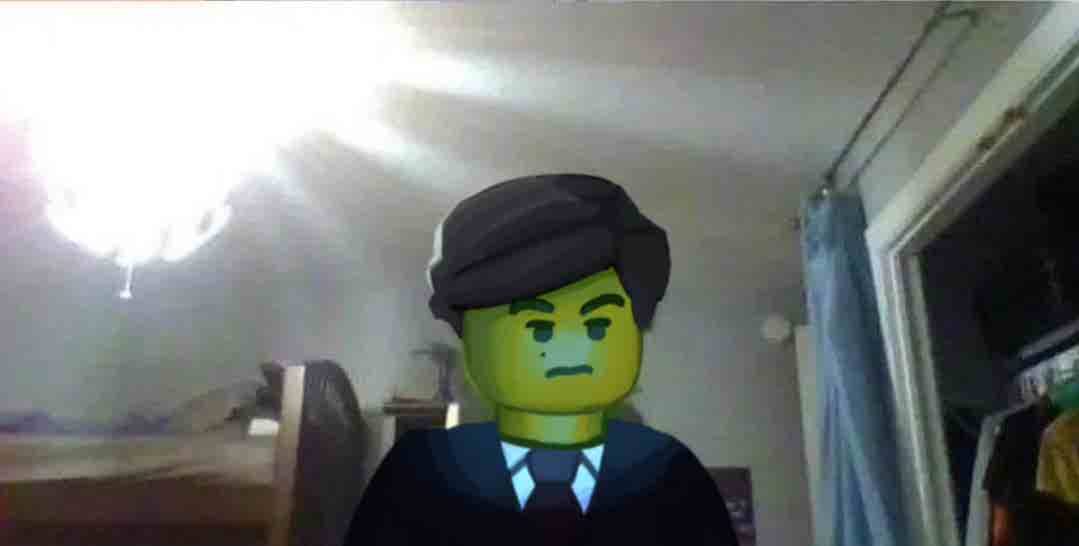 Aaron Hotchner drawn over a Lego character, looking into a laptop camera