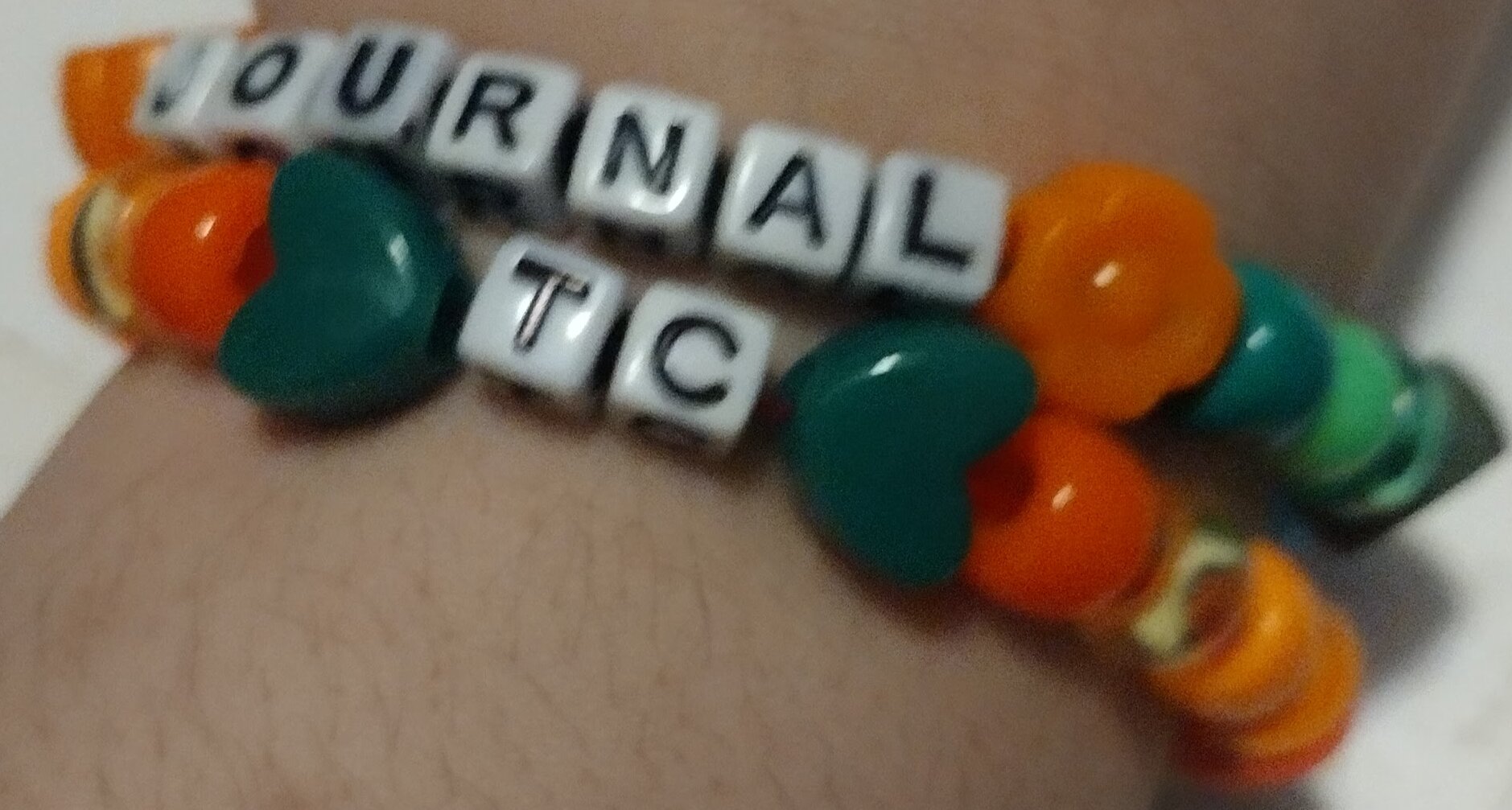 2 bracelets. Top one is Journal, bottom is TC(short for Treasure Chest). The beads next to their name match with colors from the other?