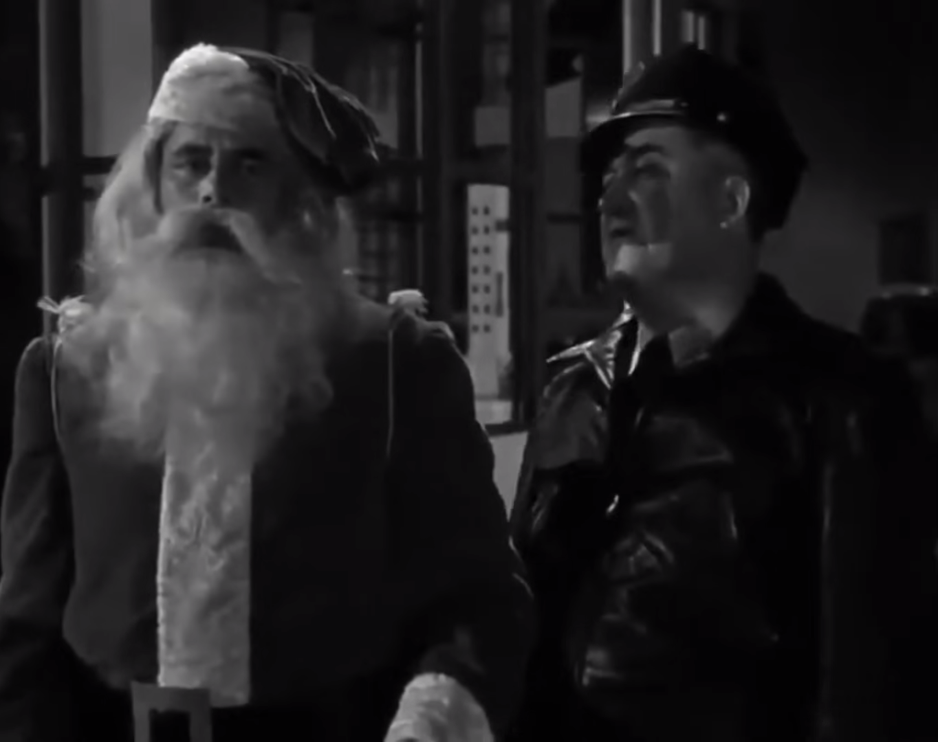 A screencap from Mr. Soft Touch. Joe Miracle (Glenn Ford) is stopped by a police officer while dressed as Santa Claus.