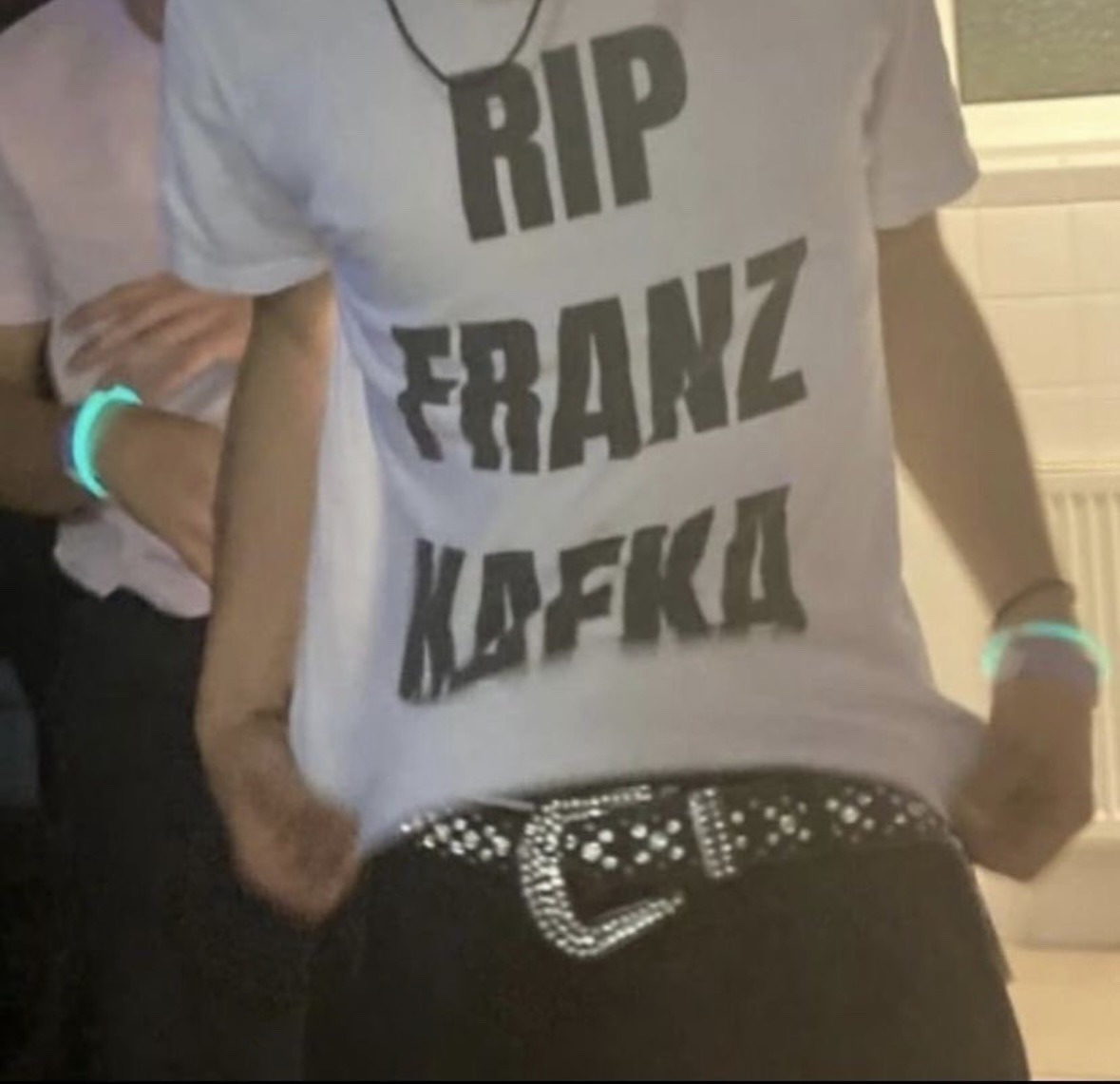 a person wearing a shirt that reads: 'RIP FRANZ KAFKA'