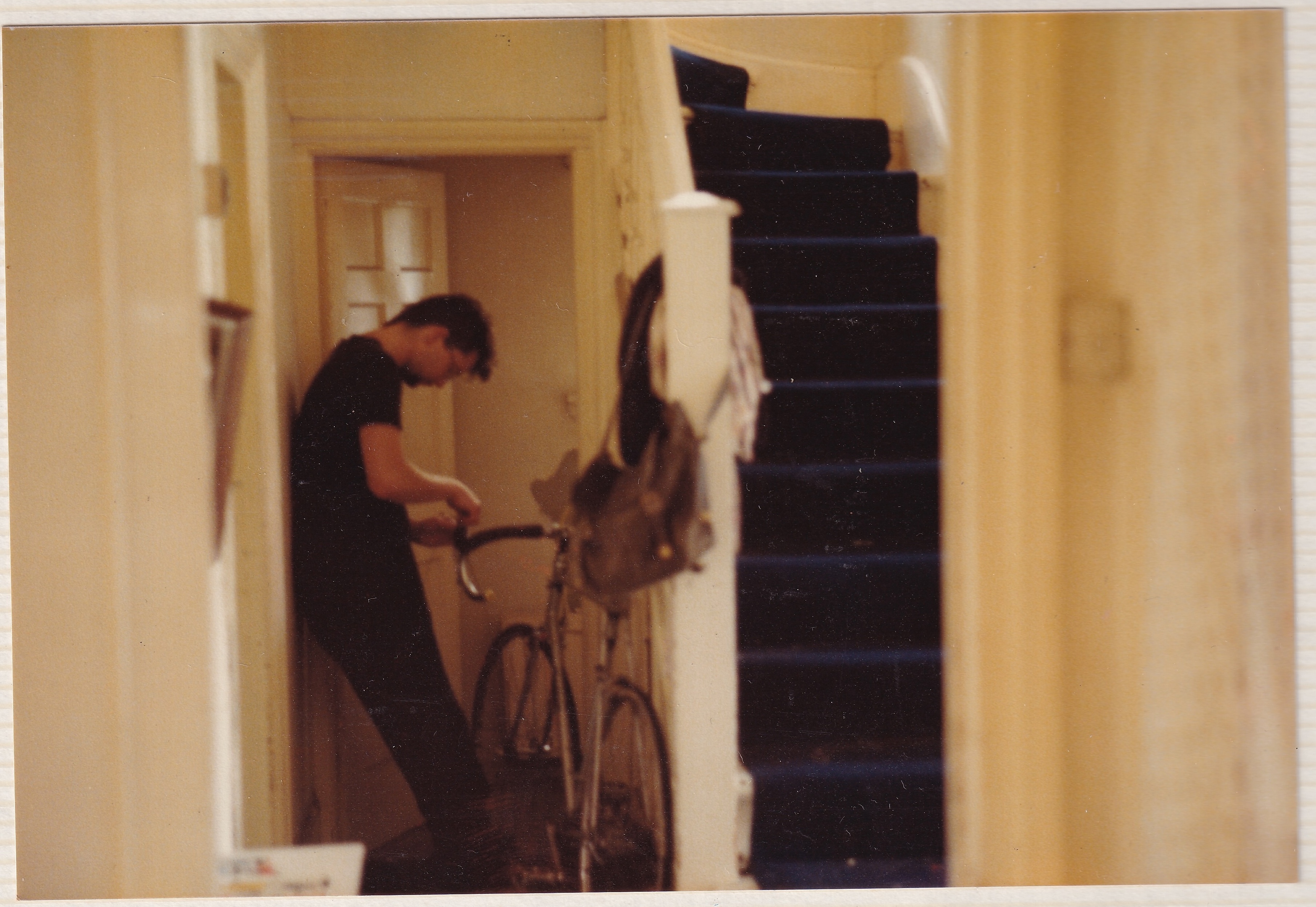 Jon in a hallway with his hands on a bike