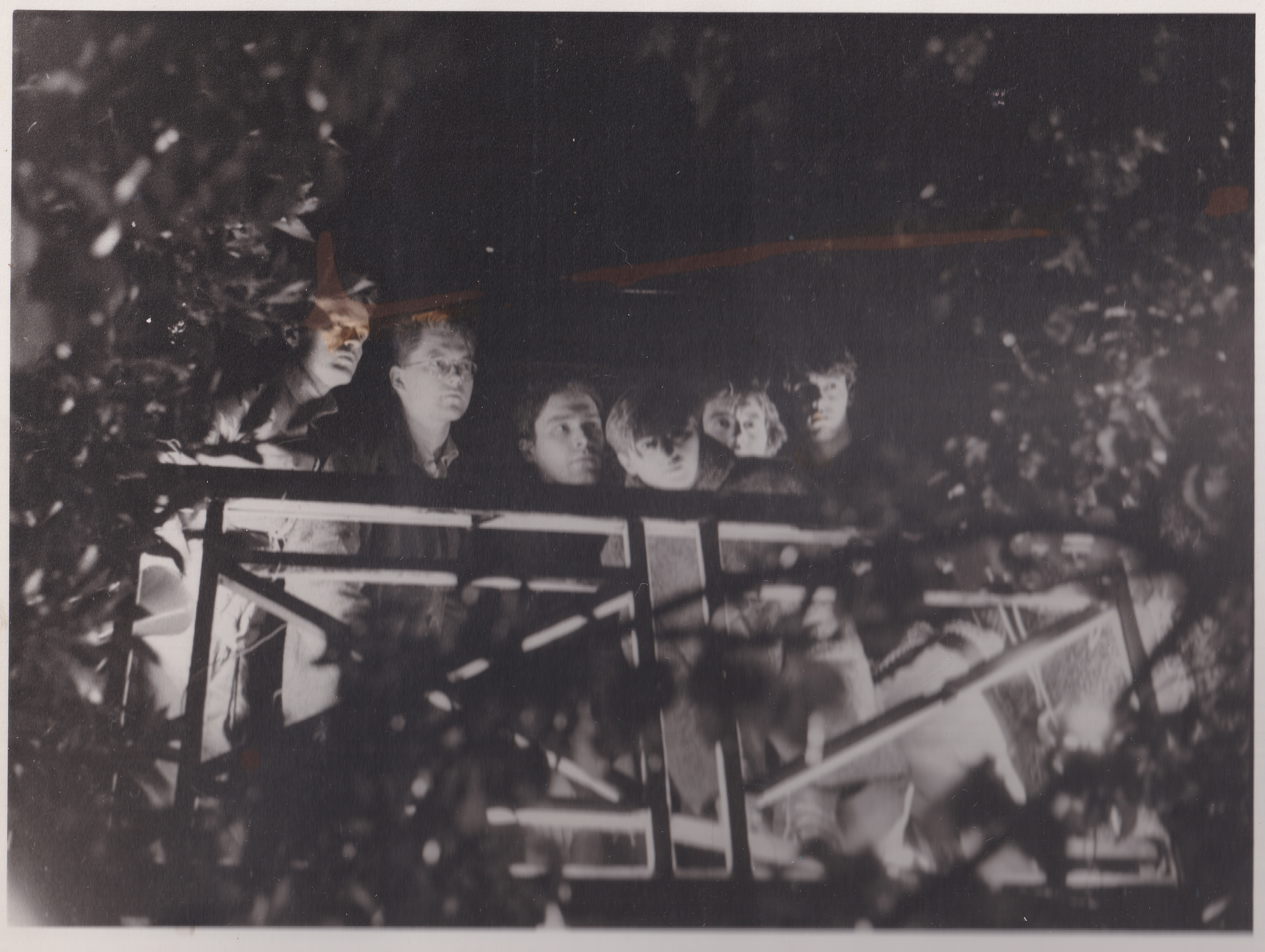 The band standing on a balcony, taken from the ground peering up at them