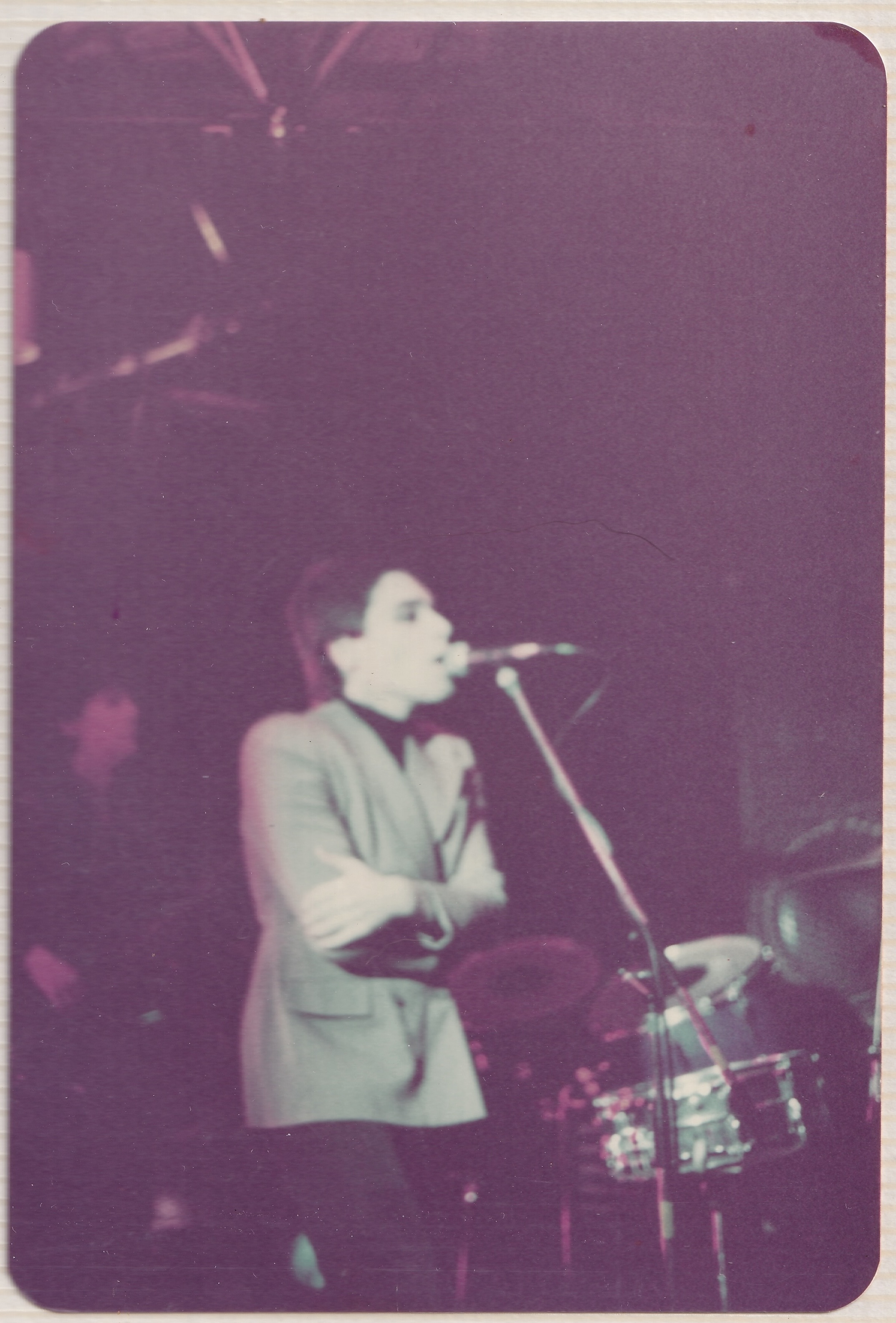 George singing onstage, Peter behind him