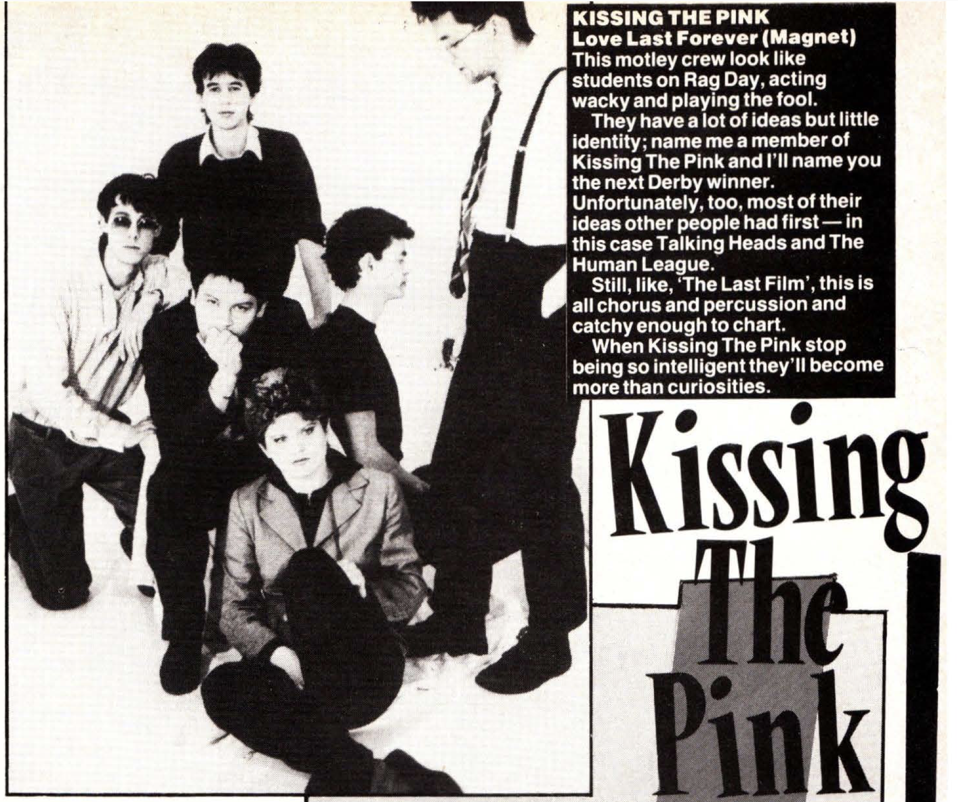 A screenshot of a magazine clipping. To the right there is text which is transcribed below, and under that there is large lettering reading Kissing the Pink. To the left, there is an image of the band which is used in other press. It consists of the 6-person Naked lineup standing in a white room. Stevie leans forward towards the camera, his arms grabbing the back of a chair. George sits in front of him on that chair, with his fist at his chin. To George's left, Nick also sits, although it's hard to tell if he's sitting on something. To George's right, Peter kneels and grabs onto the chair for stability. In front of George, Jo sits on the floor. To the left of them all, Jon is standing and looking down at the rest of them.