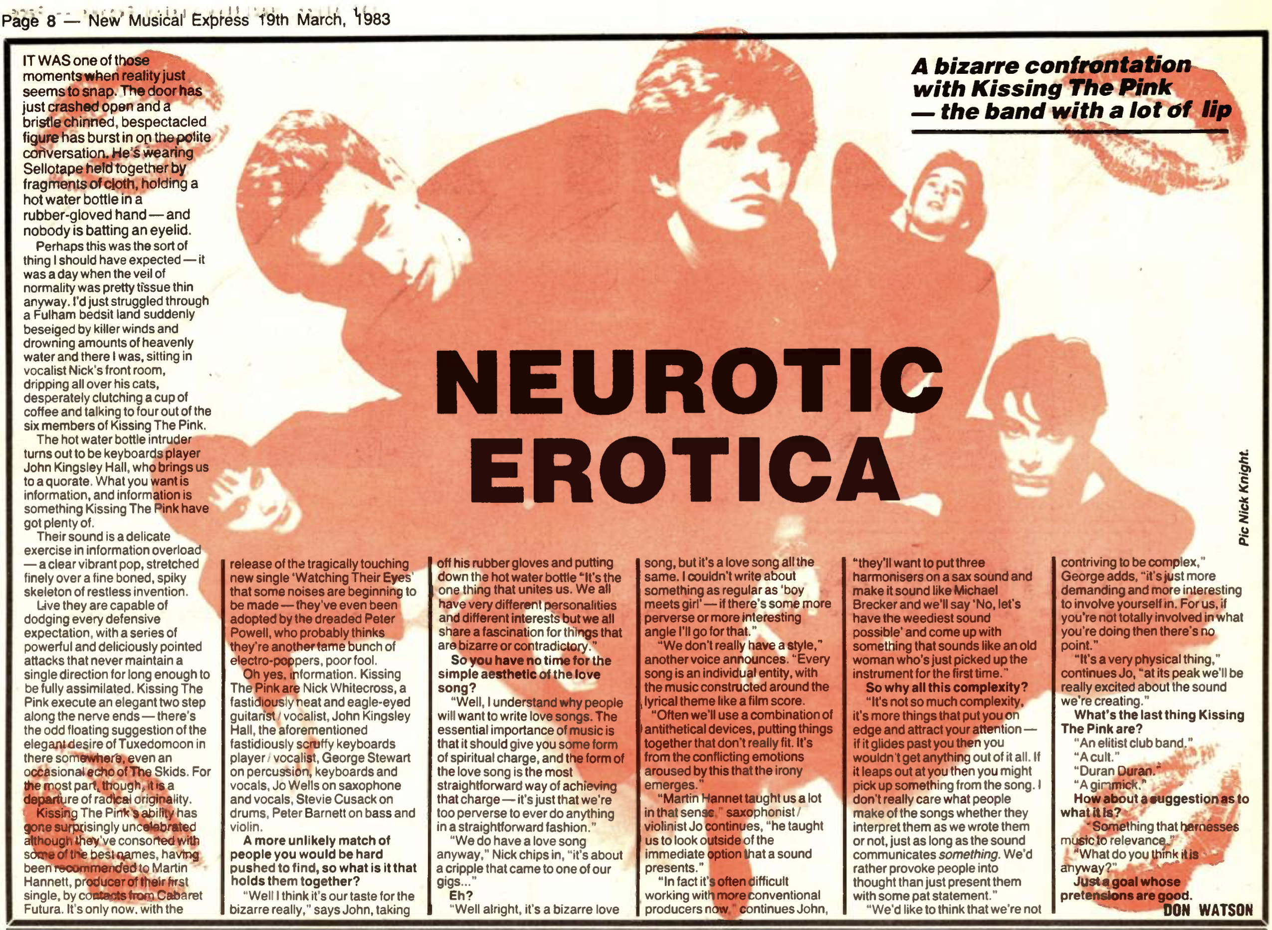 A monochrome, colorized red, magazine scan with an image featuring the Naked lineup of Kissing The Pink sans Jon. Each member is wearing dark clothes with their details indiscernible. They are all edited to overlap with each other. Nick and Jo are in the middle, Nick unnaturally tilted over her shoulder (perhaps to make him fit in the frame). Jo’s eyes look up, Nick looks into the camera. Surrounding them are George, Stevie and Peter, each lying down in a slightly different way. George lying on his side with his arms propping himself up (and being on the left of Nick), Stevie on his back with one hand resting below his head and Peter sitting up with one of his hands on his knee and the other balancing himself on the floor. On each corner of the page there is a kiss mark colorized in the same orange. Throughout the page there is text, all transcribed below.