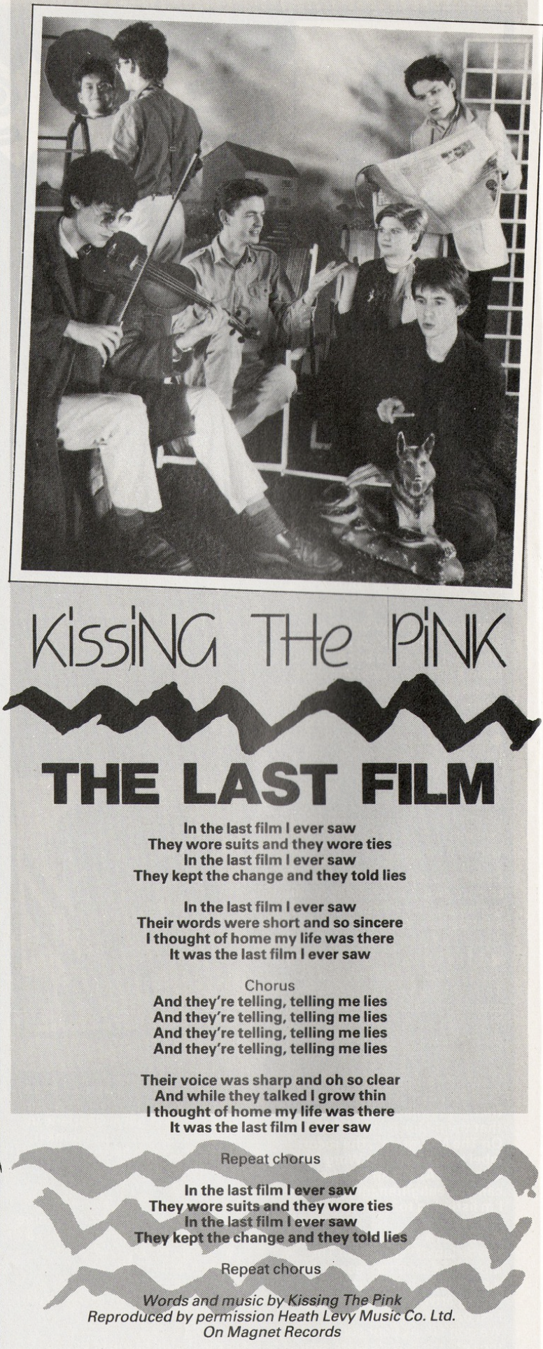 A black and white photo of the 6-member Naked lineup on a set which looks like a farmyard. Seated: Peter plays violin wearing sunglasses and a long coat. Nick and Jo are sitting on lounge chairs, facing each other, with an arm raised as if they are talking to each other. Stevie kneels next to a plastic statue of a dog, holding what looks to be a drumstick with a shocked expression on his face. Standing: Jon's back faces the camera as he looks in a circular mirror, the reflection of his face visible. George reads a newspaper. Below the photo are lyrics to The Last Film, which are not transcribed on this page.