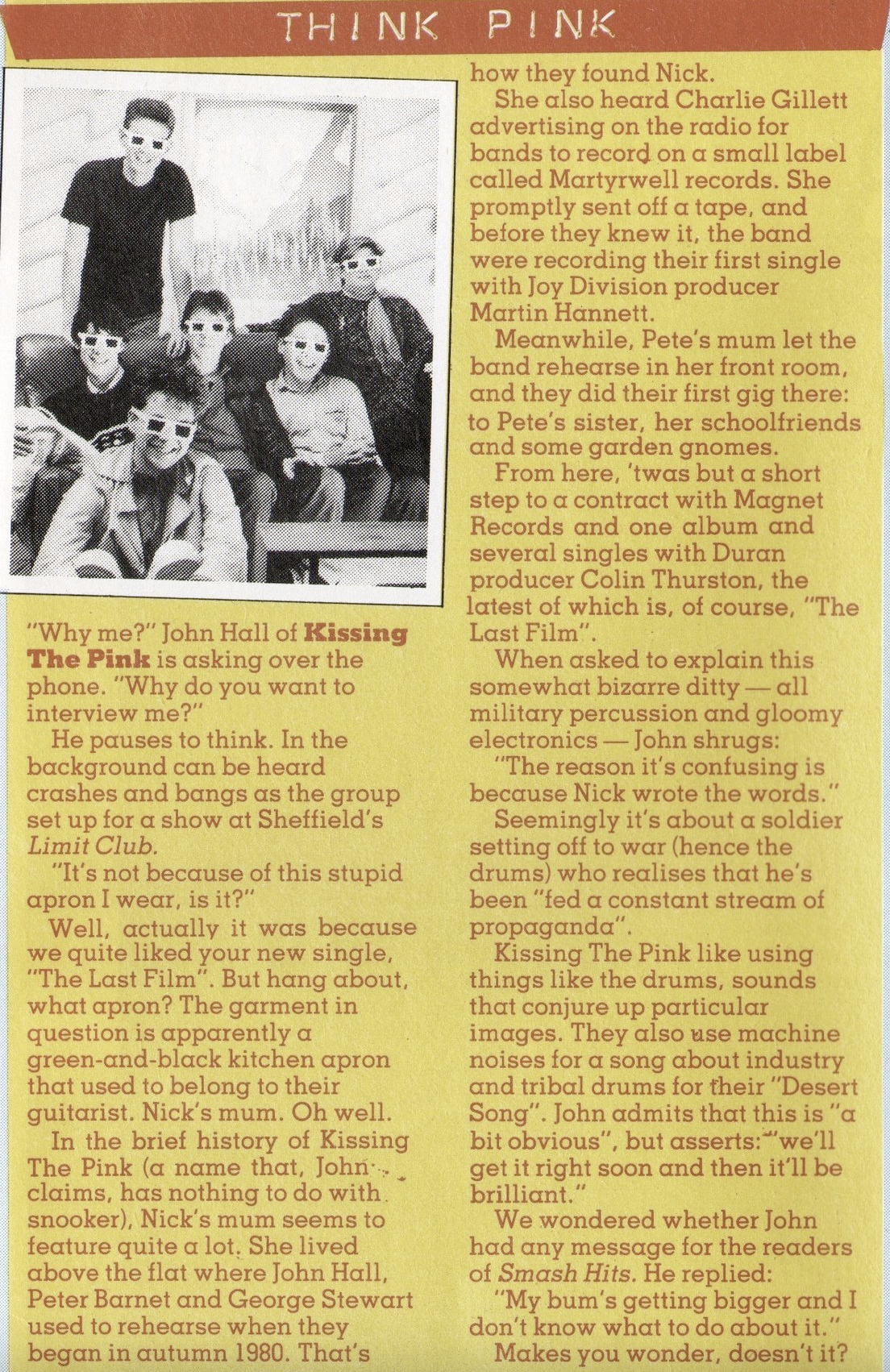 A scan clipping of an orange section of Smash Hits. Entitled THINK PINK which features an unaltered photo of one of the photos on the back of The Last Film. Where Peter, Stevie, George and Jo are sitting on a couch. Jon is in front of the couch, and Nick is leaning behind the couch. In front of Jon is a television. Each member is wearing 3D glasses. The photo is in black and white. The text of the article is transcribed below.