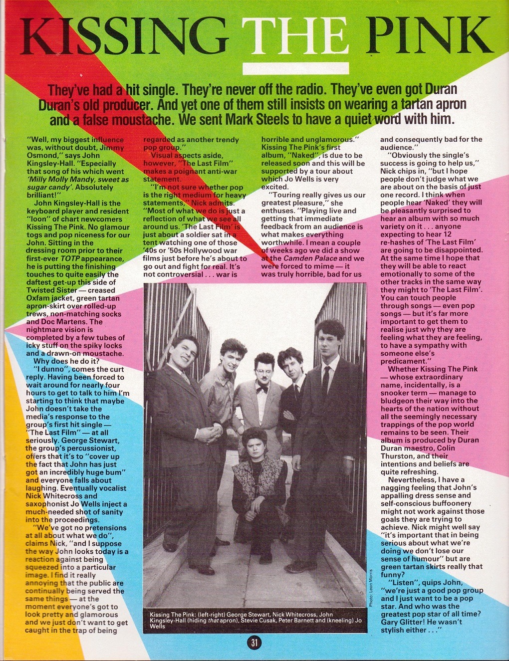 A colorful magazine page with text that is transcribed below under main article. Within this there is a photo of the 6-member band. George, Nick, Jon, Stevie and Peter all stand outside in between gates of a bridge, all smiling. Jo kneels in the middle of them, scowling.