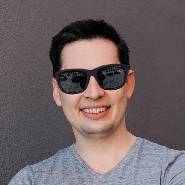 Headshot of Evgeny Kuzyakov, smiling, wearing a dark shirt