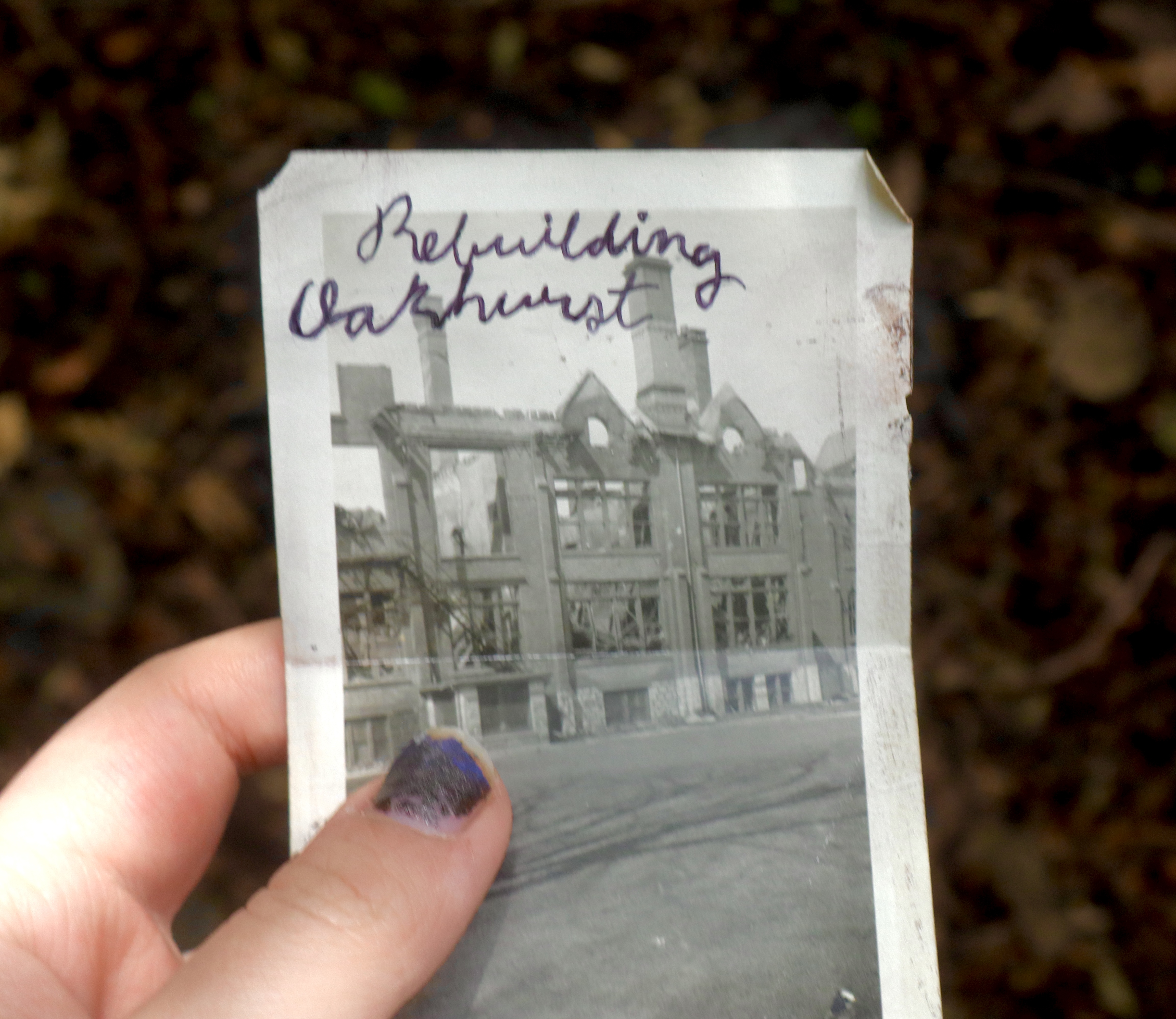 a slightly damaged black and white picture of an old, damaged building. Cursive at the top reads 'Rebuilding Oakhurst'.