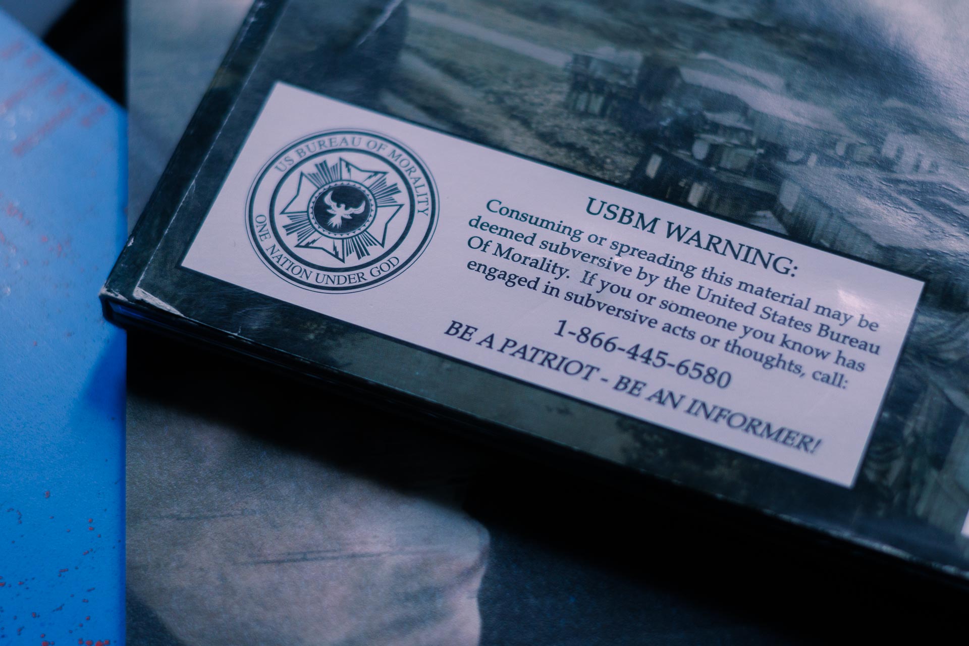 sticker on the back of the year zero CD stating: USBM WARNING - Comsuming or spreading this material may be deemed subversive by the United States Bureau of Morality. If you or someone you know has engaged in subversive acts or thoughts call: 1-866-445-6580