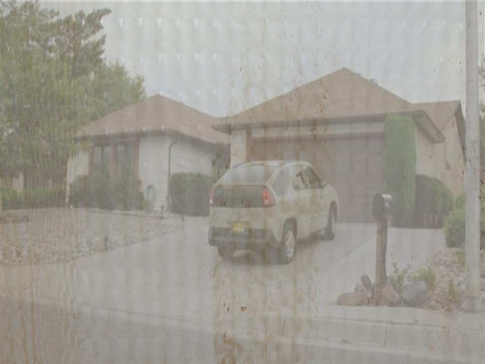 The window of Jesse's RV obscured by shower curtains revealing he's parked in front of Walter's house.