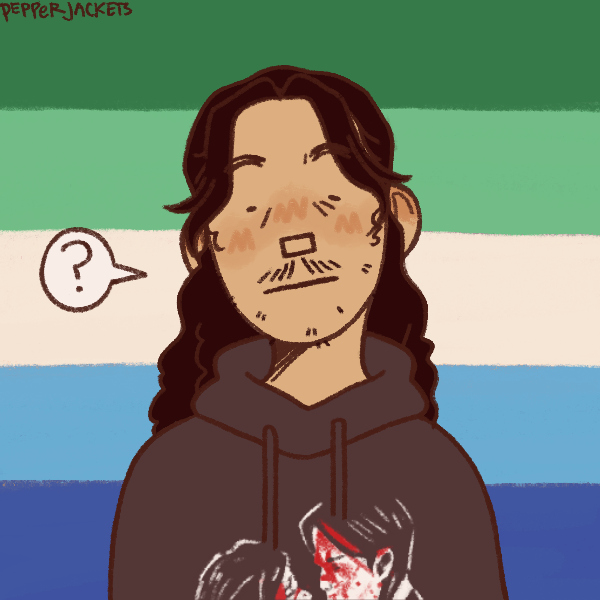man with long hair and scrappy facial hair in front of gay male pride flag