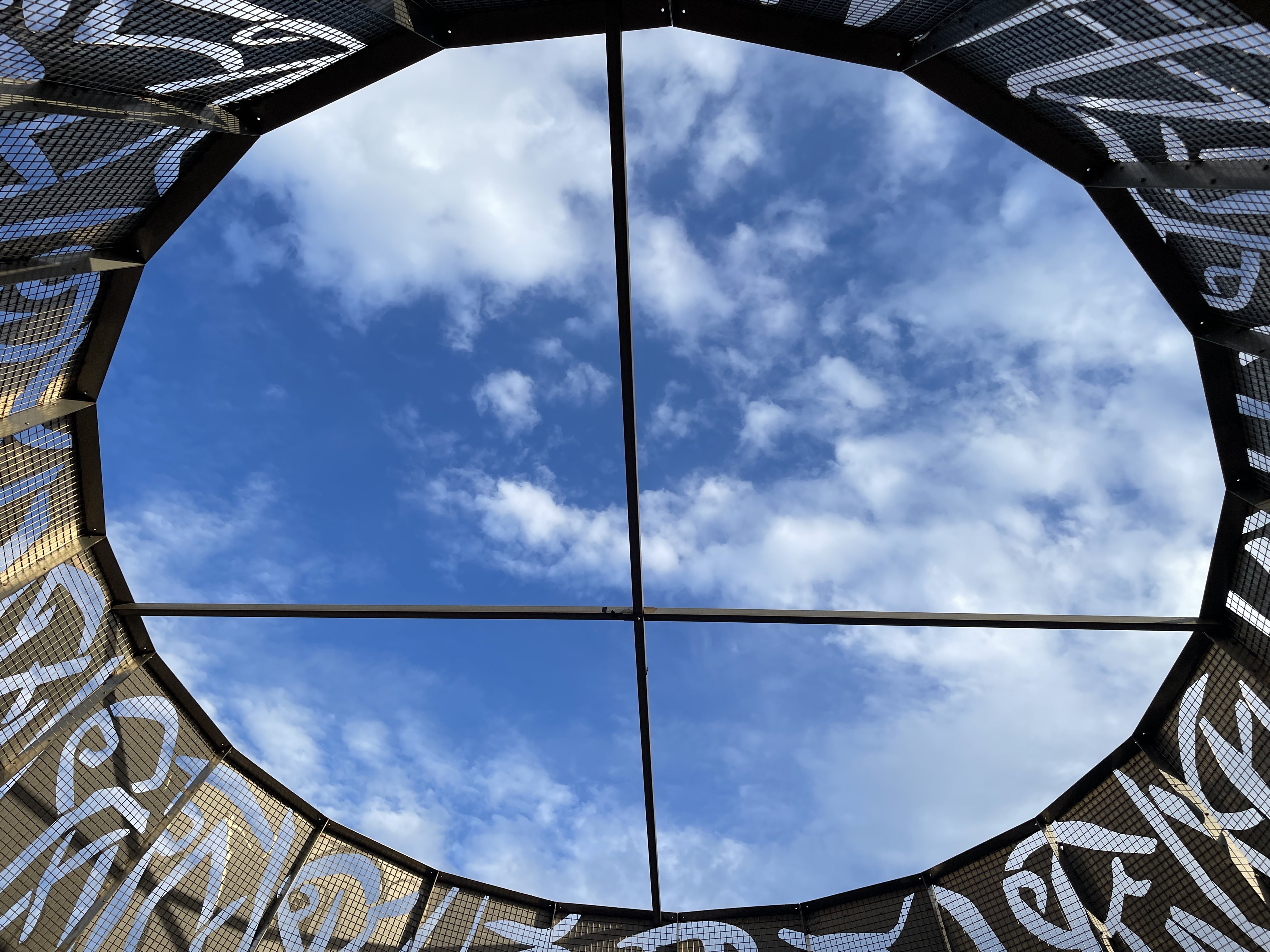 The sky with clouds seen from a window-like structure.