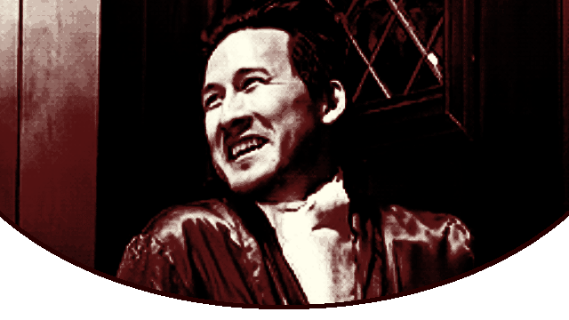 a gif of actor mark moving his thumb across his throat and making a face as if he died then smiling after in amusment