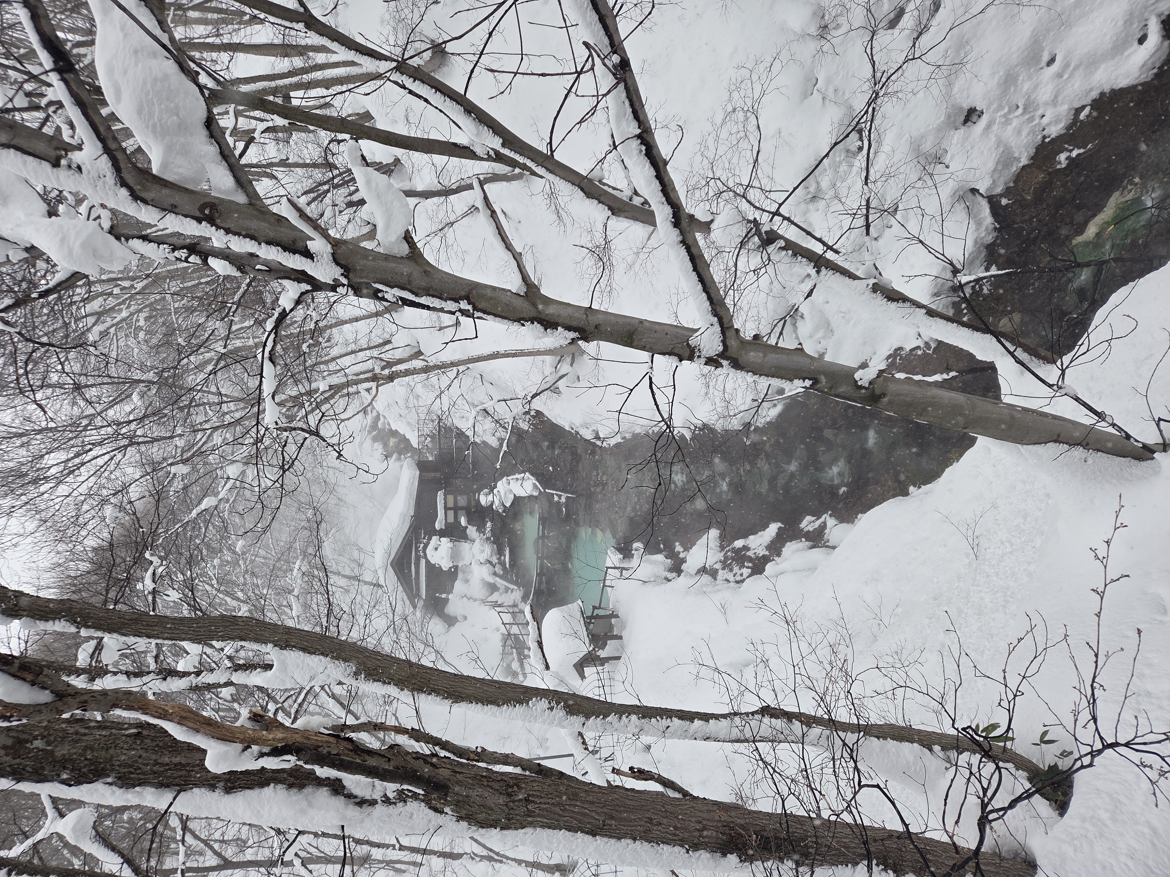 View of a natural sulphur hot spring onsen from a small\nbridge