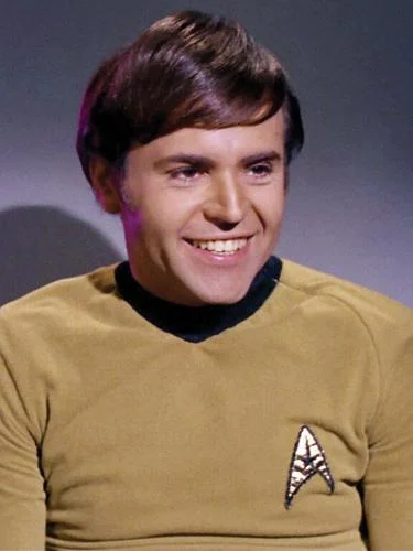 a man with side-swept hair in a yellow uniform