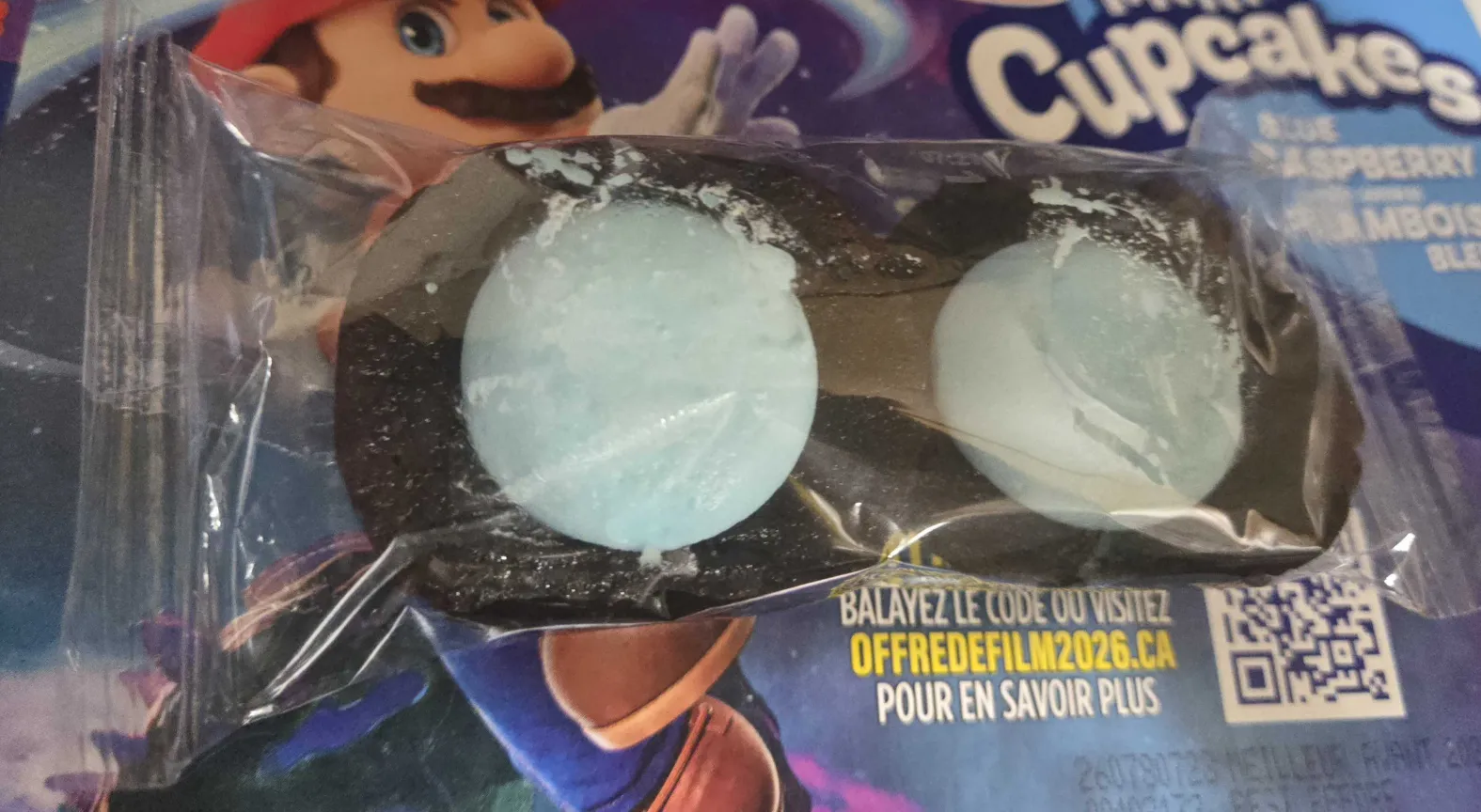 An individually wrapped pair of the blue raspberry chocolate mini cupcakes.