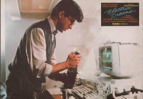 Lenny Von Dohlen's character Miles with a champagne bottle over a smoking, overheating 80s computer.