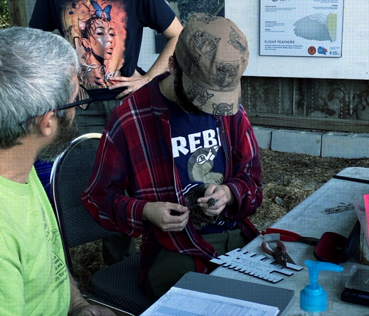 photo of Me working at a banding station, checking the wing of a yellow-rumped warbler