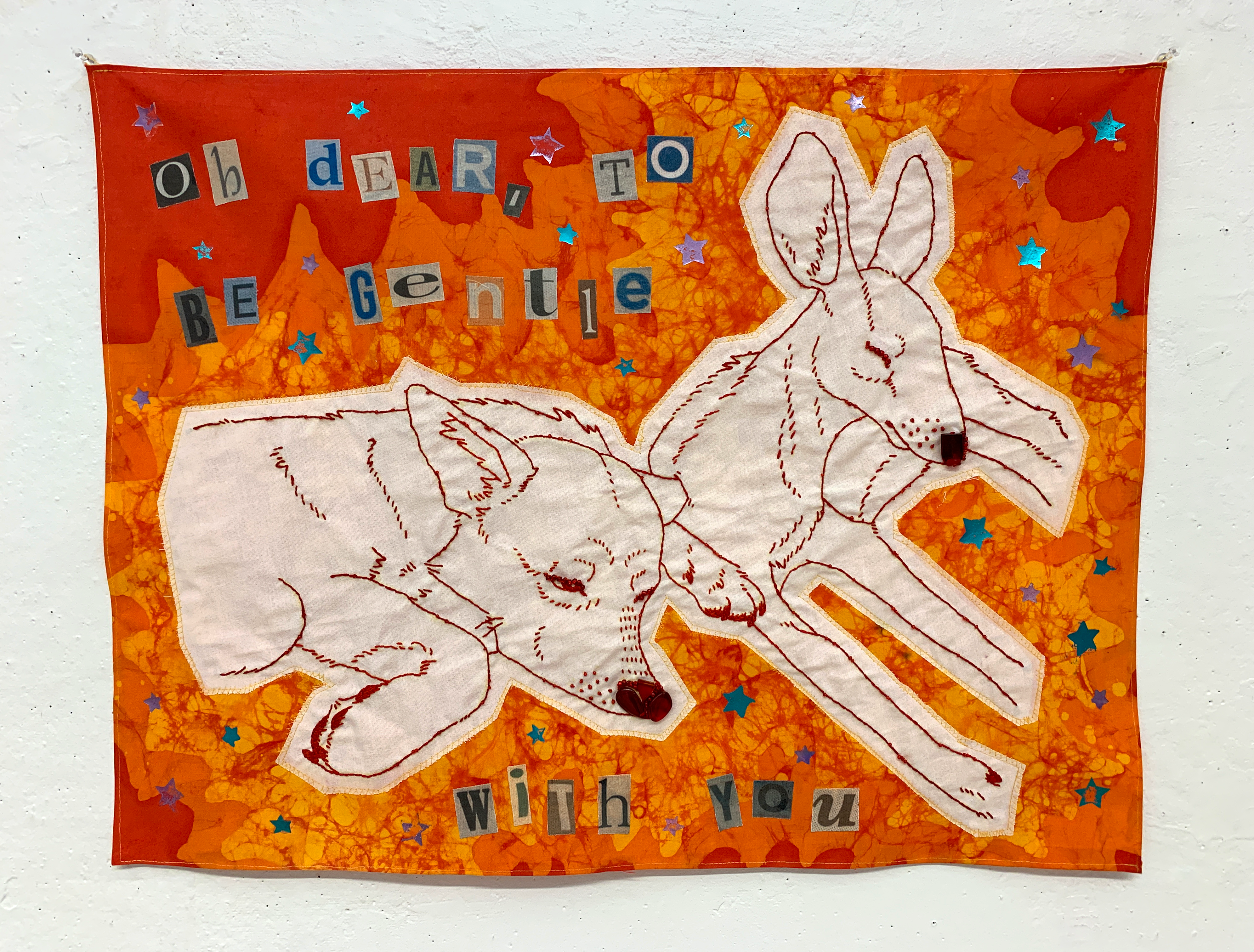 fiber art piece using fabric, beads, and embroidery, depicting a deer and a dog with text that reads 'oh dear, to be gentle with you'