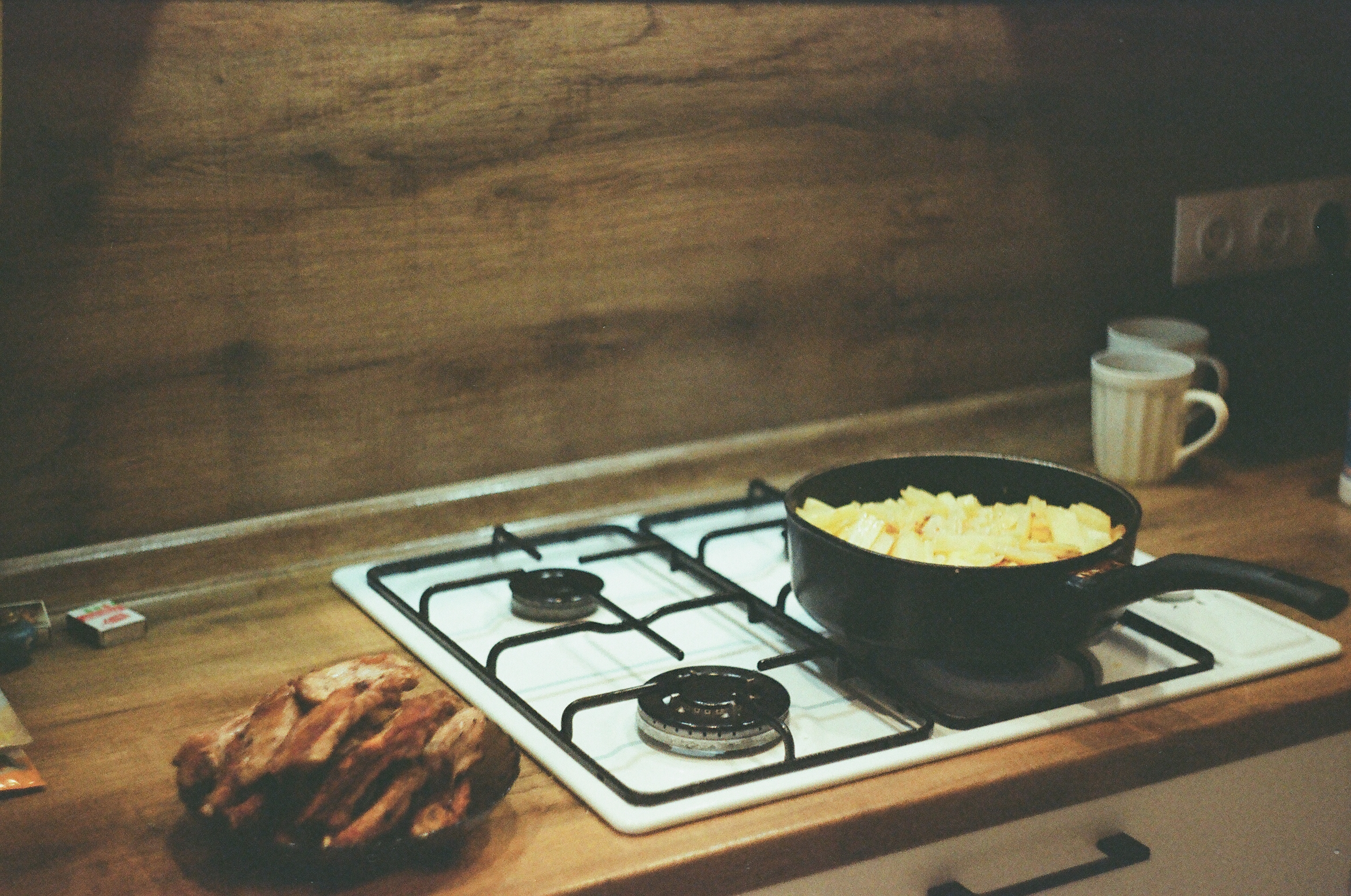 A pan of fries on the stove and a bowl of fried ribs