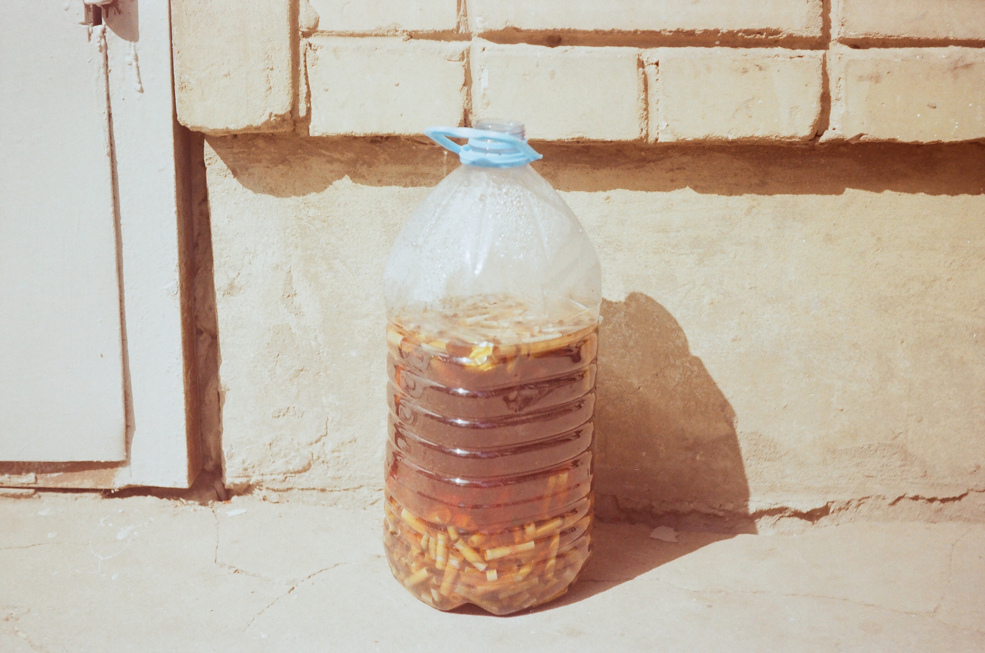 Big bottle with drowned cigarette buts