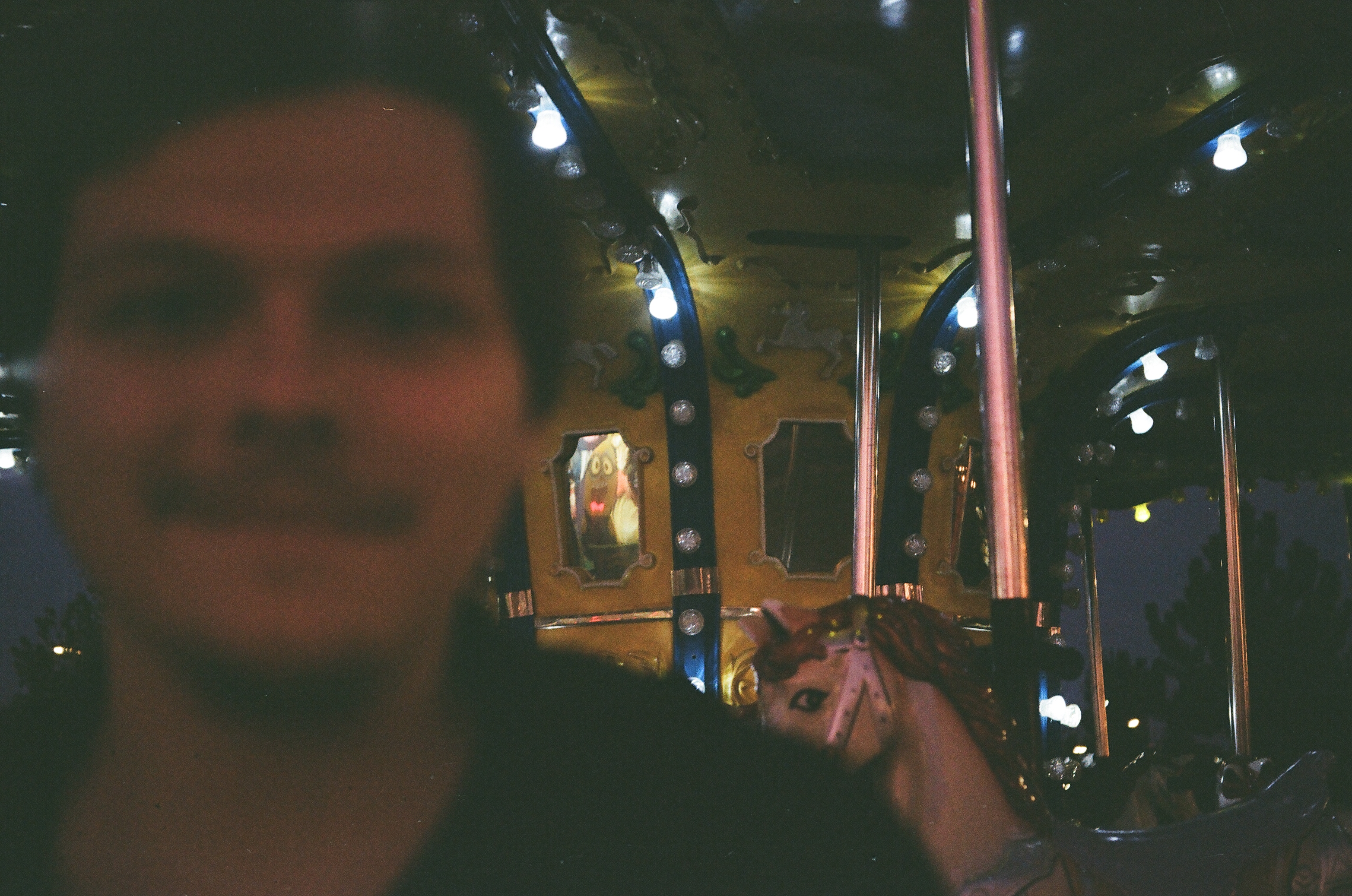 Blurry portrait with a merry-go-round behind