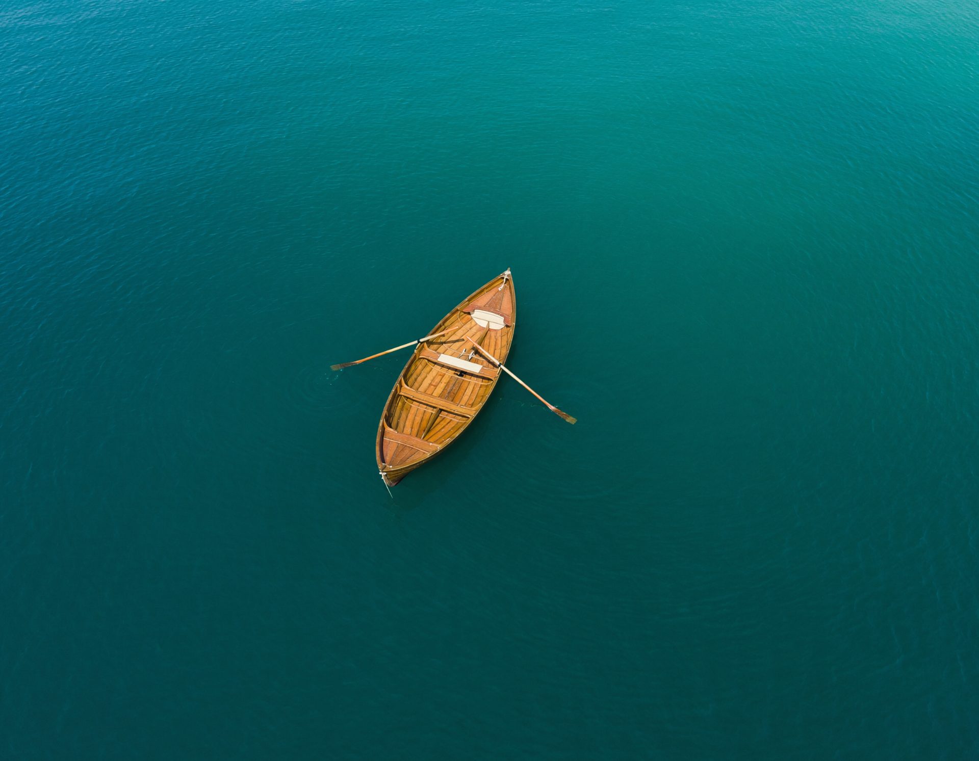 Solitary Wooden Boat on Teal Water